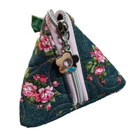 A handmade triangular fabric pouch with a dark blue floral print, pink roses, and a light pink zipper.
