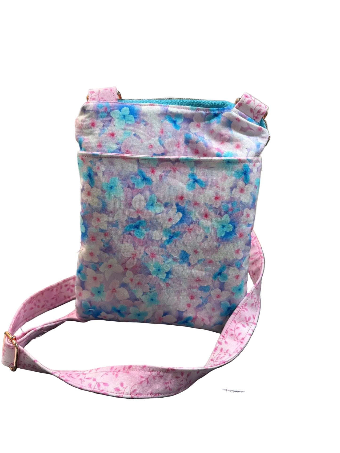 A small fabric shoulder bag with a pastel floral print in pink, blue, and white.