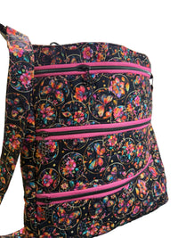 A fabric tote bag with a black background and a colorful butterfly and floral pattern, featuring three horizontal pink zippers.