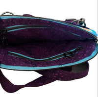 A purple patterned crossbody bag with a light blue zipper trim.