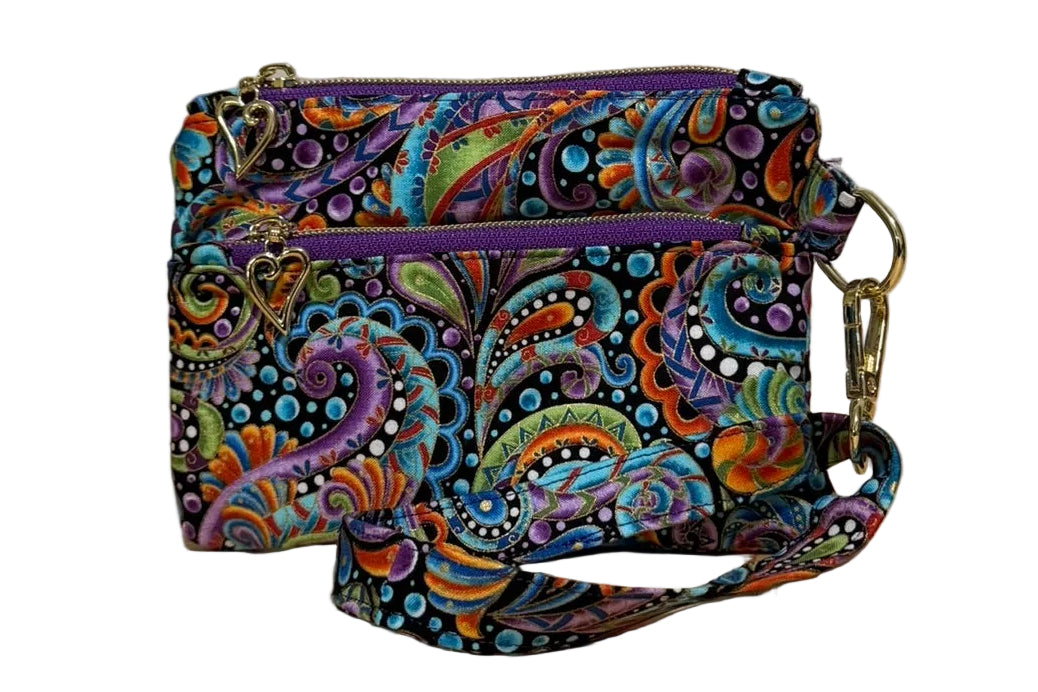 Carnival Swirl Swing Bag Mini wristlet with two front zip pockets and a wrist strap in bright paisley fabric