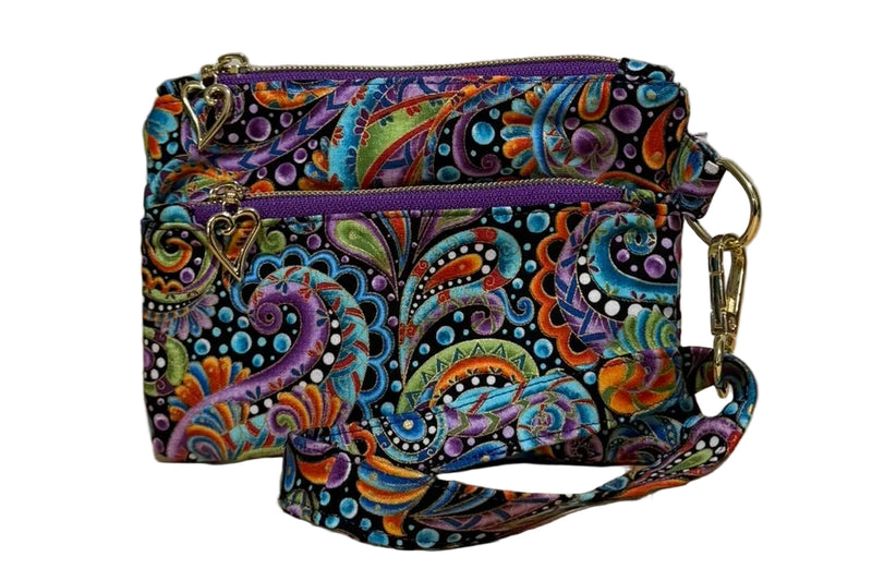 Carnival Swirl Swing Bag Mini wristlet with two front zip pockets and a wrist strap in bright paisley fabric