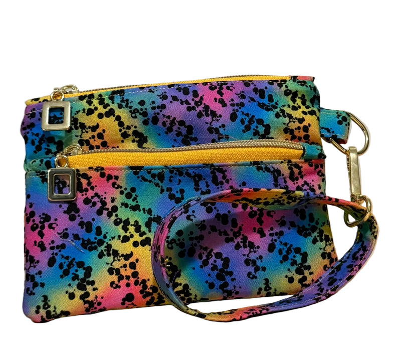 Rainbow Riot Swing Bag Mini wristlet with two front zip compartments and a wrist strap in rainbow splatter fabric