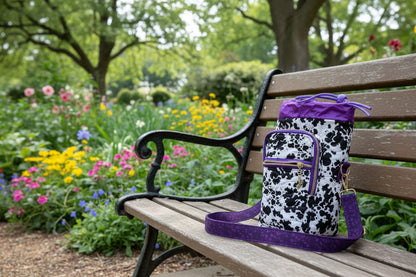 Backpack with cow print pattern and purple accents on a wooden surface